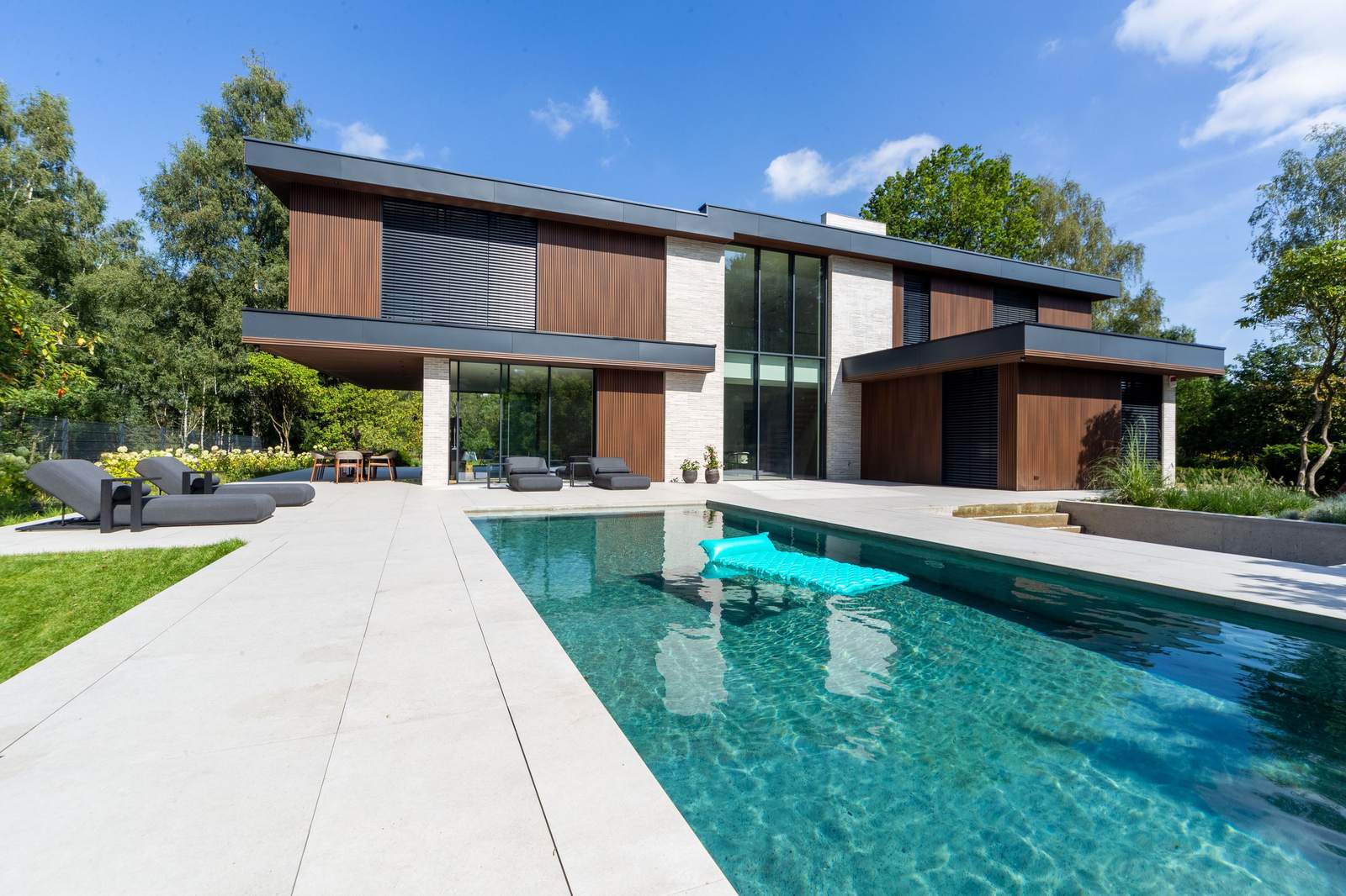 Modernes Haus mit Pool unter blauem Himmel